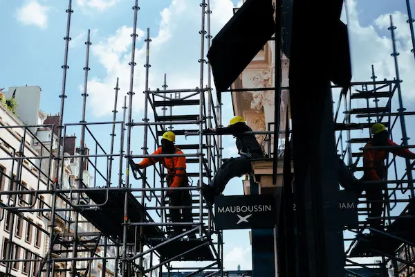 des professionnels du bâtiment en train de travailler sur un échaffaudage avec des