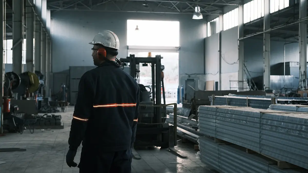 un agent de travail sur un site industriel vétu de vêtements de travail